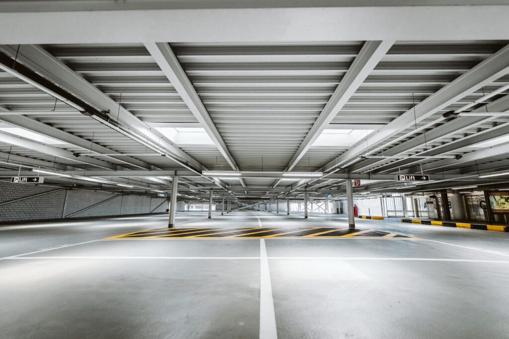 Bilden visar ett parkeringsgarage. Skurmaskin, åkbar skurmaskin kan städa stora ytor snabbare.