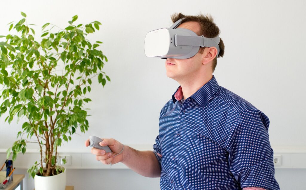 Bilden visar en person med ett VR headset. Playstation VR 2 kan göra din PS VR 2 upplevelsen ännu mer verklighetstrogen.