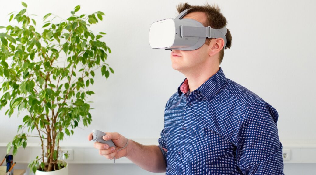 Bilden visar en person med ett VR headset. Playstation VR 2 kan göra din PS VR 2 upplevelsen ännu mer verklighetstrogen.
